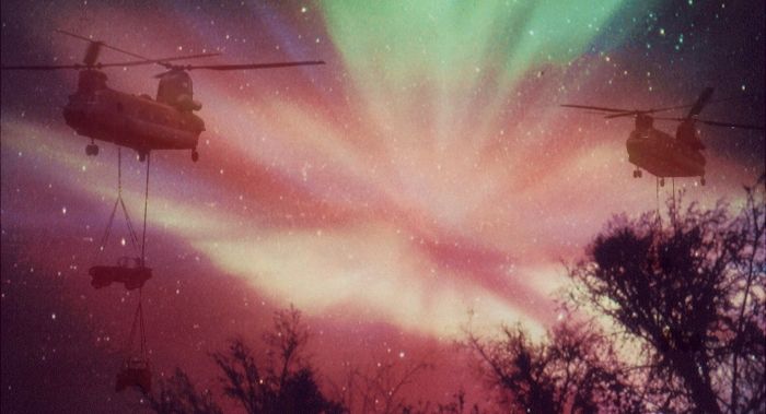 CH-47D Chinooks sling cargo under the Northern Lights.