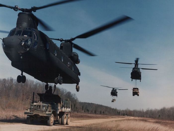 Boeing CH-47D Chinook helicopter's externally transporting five ton cargo trucks.