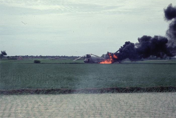 CH-47A Chinook helicopter 65-07989 as it lay in a rice patty burning after being shot down by enemy fire in the Republic of Vietnam.