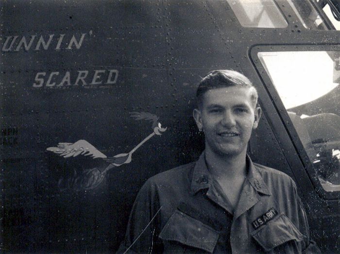 Flight Engineer SP5 Ronald P. Wetherell standing near the Nose Art just forward of the main cabin door of 65-08024.
