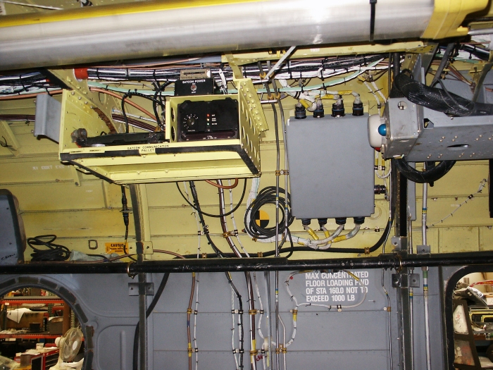 The left forward main cabin area of CH-47D Chinook helicopter 85-24336 showing a micro climate unit (MCU) mount (extreme right side with relocated troop alarm), the intercom control system (ICS) control unit (center) and the satellite communications pallet (left).