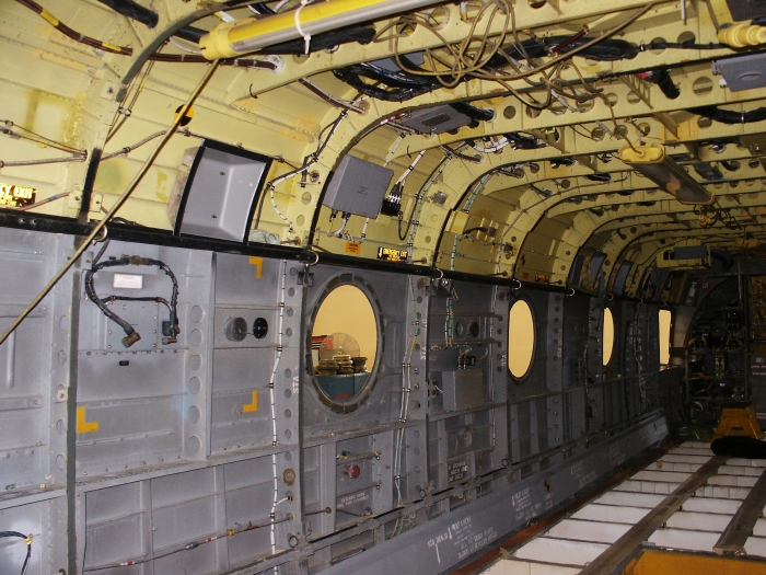 The right forward main cabin area of CH-47D Chinook helicopter 85-24336 looking aft showing the cargo hook control unit, the right side fuel pump relay control box, and the number two engine Digital Electronic Control Unit (DECU).