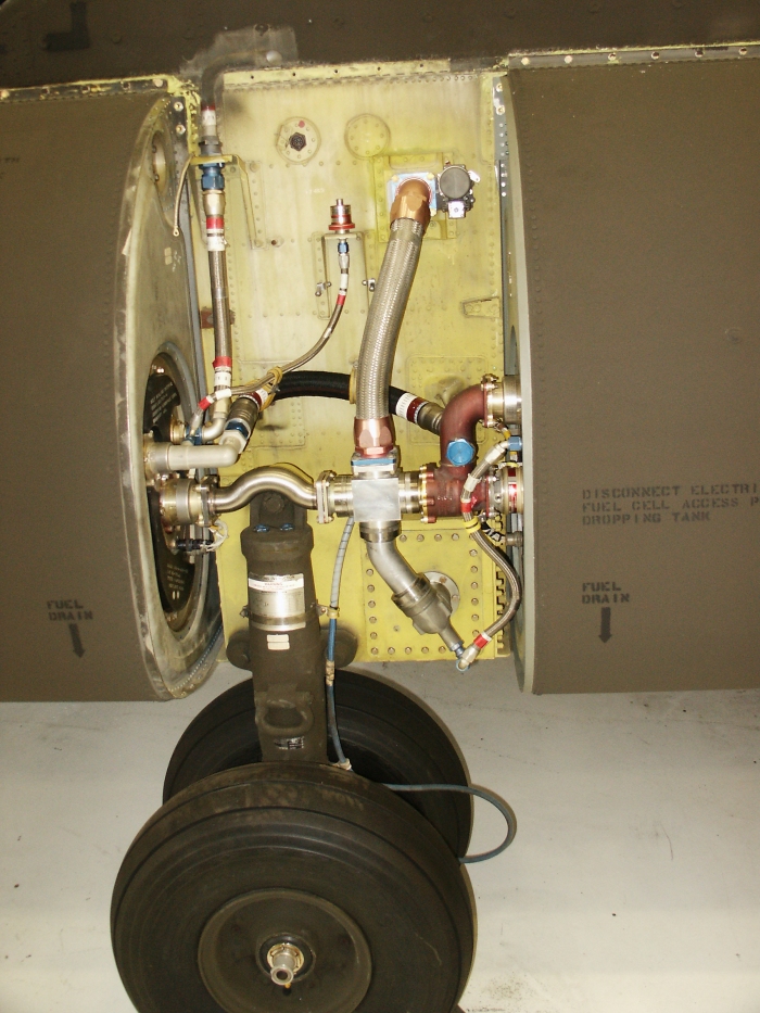 The right forward landing gear area of CH-47D Chinook helicopter 85-24336 showing the forward auxiliary fuel tank pressure switch and break away fuel fittings.