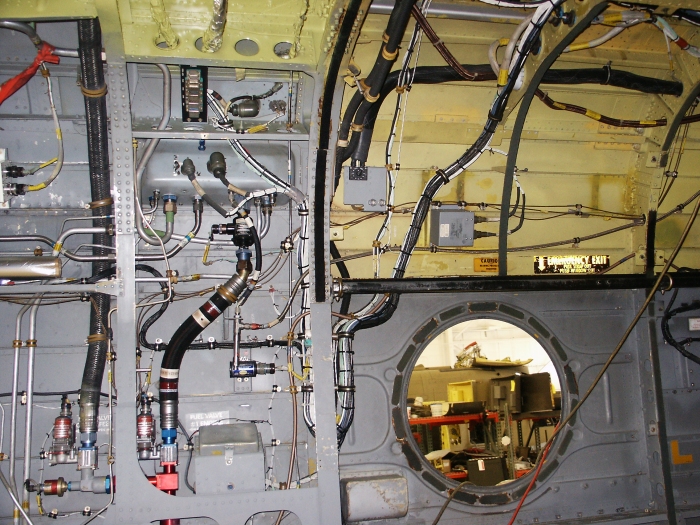 The left rear ramp area of CH-47D Chinook helicopter 85-24336 showing the cross feed and engine fuel shut off valves, various fuel lines and fittings and engine control relays under the number one engine.