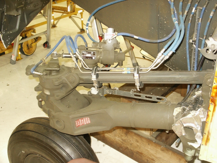 The right aft landing gear area of CH-47D Chinook helicopter 85-24336 showing the gear, drag brace, drag link and the power steering actuator.