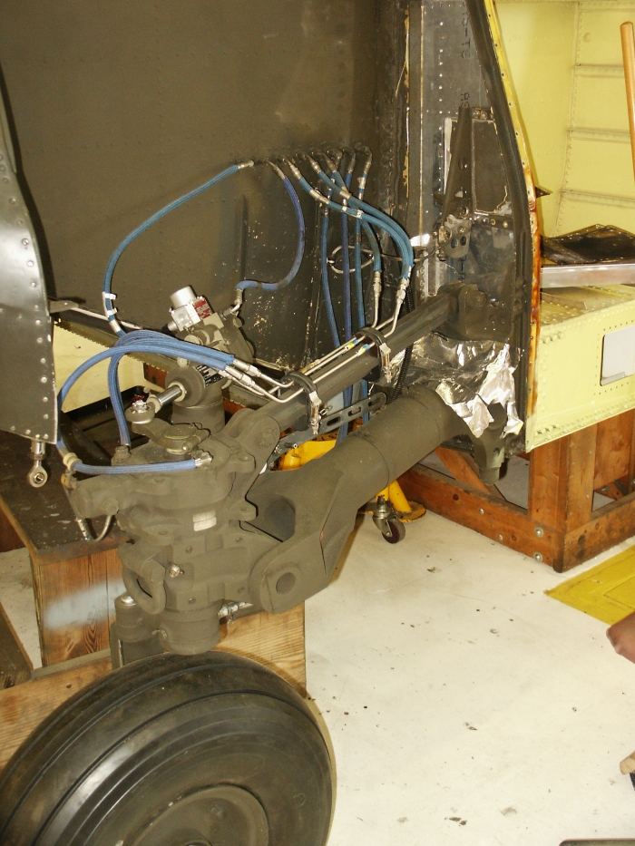 The right aft landing gear area of CH-47D Chinook helicopter 85-24336 showing the gear, drag brace, drag link and the power steering actuator.