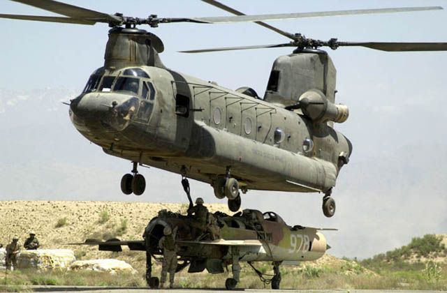 An Afghan MIG-21 wreck is lifted by CH-47D Chinook 86-01649 at Bagram Air Base, Afghanistan, circa 2002.