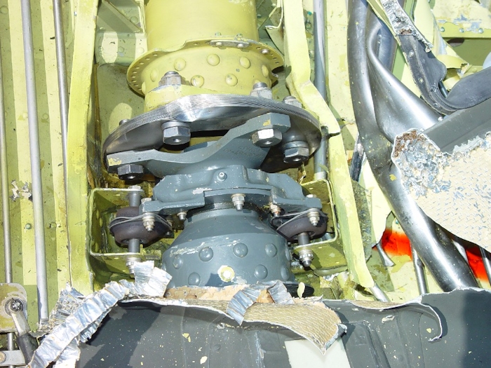 July 2002: The Flex Pack (Thomas Coupling) on the drive shaft took a direct hit from the blade as evidenced by the large dent. The drive shafts (synchronizing or just sync shafts) allow the drive train to flex during flight operations. There are seven individual sync shafts in the forward section of the helicopter and two in the rear. As the helicopter flies, the fuselage twists and turns. Without the flex packs to absorb this movement, the drive train would be too rigid and it would fail.