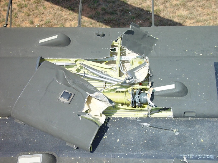 July 2002: A wider look at the damage to the airframe. The three forward formation lights can be seen. The number one tunnel cover has a single formation light mounted on the top. The number two tunnel cover was displaced and nearly removed from the airframe. Half a tunnel cover support strut can be seen to the right of the tunnel covers as well as debris from the number one tunnel cover just above the forward top step.