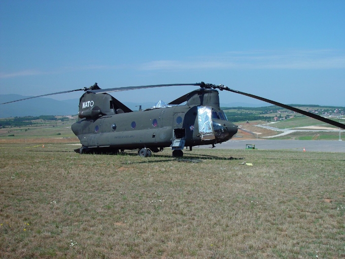 July 2002: Sitting in the grass at Camp Bondsteel, Serbia, this photograph shows 89-00138 in the days following the accident. Support personnel have covered the vunerable areas with protective barrier material to prevent further damage.