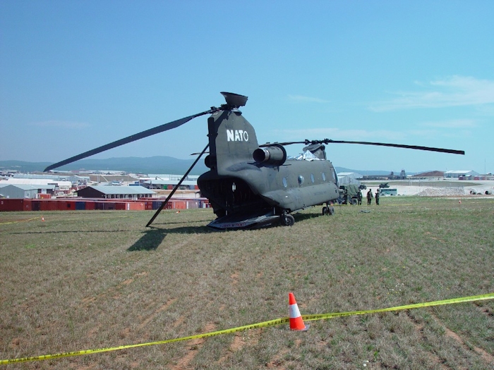 July 2002: Sitting in the grass at Camp Bondsteel, Serbia, this photograph shows 89-00138 in the days following the accident. Support personnel have covered the vunerable areas with protective barrier material to prevent further damage.