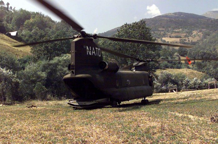 U.S. Army Chinook helicopter 89-00164 drops off personnel at the weapons collection point near Tetovo, in the former Yugoslav Republic of Macedonia, during Operation Essential Harvest (Task Force Harvest), which was conducted from August through September 2001. North Atlantic Treaty Organization (NATO) forces were collecting weapons from the local citizens on a voluntary basis. Stenciled on the back end of the ramp was the name "Battle Pig".