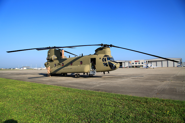 16 August 2017: CH-47F Chinook helicopter 15-08191 sitting during preflight inspection at Indianapolis Regional Airport (KMQJ), Indiana, while enroute to it's new home at Butts Army Airfield (KFCS), Fort Carson, Colorado. The aircraft was manned by civilian aircrews from System Engineering Services (SES) of Huntsville, Alabama during the ferry flight mission. Tim Coffman, serving as Flight Engineer, preflights the top of the aircraft while Kevin Hoffmaster, pilot, inspects the bottom.
