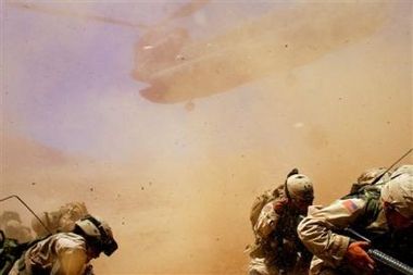 U.S. soldiers shelter from the dust kicked up by a Chinook helicopter as it lands to pick them up from Bagh village, in Khakeran Valley, Zabul province, Afghanistan, June 26, 2005. From U.S. and U.N. officials down to Afghan villagers, there is growing fear that this country may be at a seminal moment with three years of state-building in danger of succumbing to the barrage of violence.