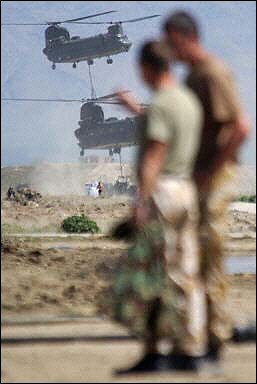 British Royal Marines watch Chinook helicopters dropping cargo at Bagram Air Base in June 2003.