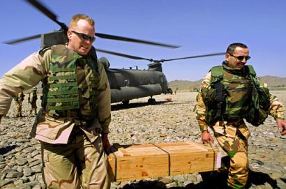 A U.S. soldier, left, assists an Italian counterpart in carrying ammunition cases out of a Chinook.