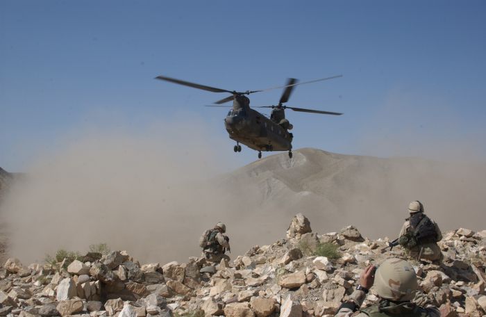 Clouds of dust are kicked up by the rotor wash of a CH-47D Chinook helicopter as it comes in for a landing to pick up security forces during a Humanitarian Aid mission in Afghanistan. Family members of the soldiers of Task Force Pirate donated shoes, clothes and food, which were distributed to residents of a village called Jegdalek.