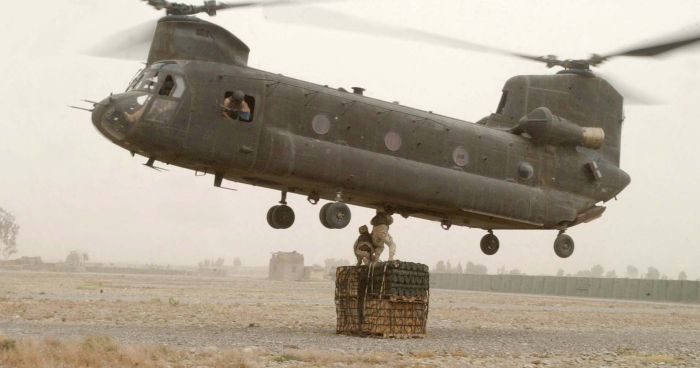 SGT Matthew Targgart (left) and 1st Lt. Jose Carmona, Logistics Task Force 524, hook a pallet of ammunition to a CH-47 Chinook helicopter for delivery to soldiers at Forward Operating Base Lwara, Afghanistan.