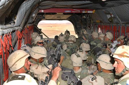 Soldiers from the American 101st Airborne Division pack into a Chinook.