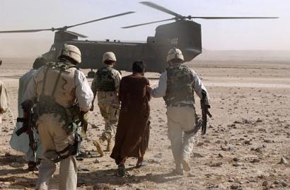 Afghan detainee being escorted to a waiting CH-47D Chinook helicopter.