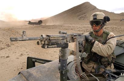 Wednesday, 3 December 2003, Paktia Province, Afghanistan: U.S. Army Sergeant Ryan F. Leonard, of the 10th Mountain Brigade Combat Observation Lazing Team, mans the truck mounted 240B machine gun. Seen in the background, a CH-47D Chinook helicopter conducts transport operations. Bravo Company, 1st Battalion, 87 Infantry, 10th Mountain division was operating as part of Operation Mountain Avalanche.