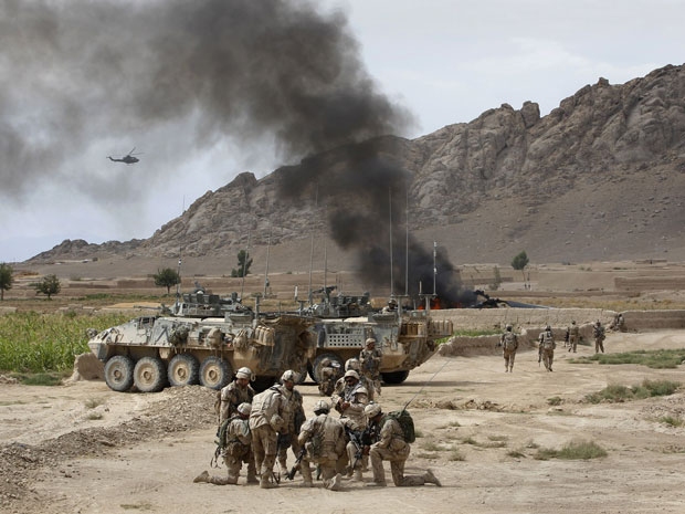 Canadian soldiers gather near a burning Canadian Forces CH-147 Chinook helicopter after it made a hard landing close to the village of Bazaar e Panjway, in the Panjway district west of Kandahar on 5 August 2010.