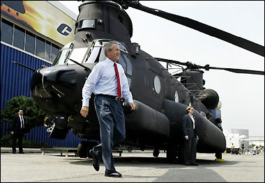 US President George W. Bush walks past a Boeing MH-47G Chinook helicopter during his tour of the Boeing Plant in Ridley Park, Pennsylvania while stumping for reelection.