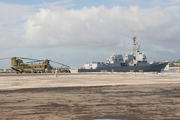19 November 2010: Boeing Mechanics and S3 NET Team aircrews prep CH-47F Chinook helicopter 07-08743 to be the first aircraft to depart the dock at Pearl Harbor as a large navy vessel glides gently by on it's way out to sea.
