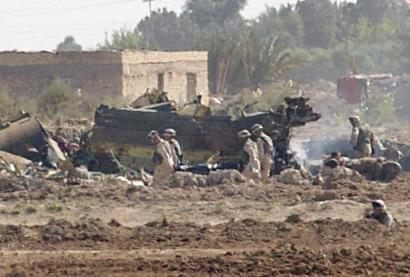 U.S. soldiers carry a stretcher to the scene after a U.S. Chinook helicopter, right, believed to be carrying dozens of soldiers to leaves abroad was struck by a missile and crashed west of Baghdad, near Fallujah on Sunday, 2 November 2003, killing 15 soldiers and wounding 26 others, the U.S. command and witnesses reported.