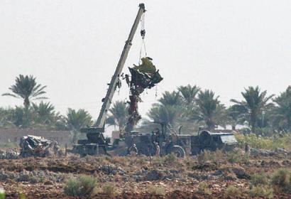 A crane lifts debris of a U.S. Chinook helicopter on Monday, 3 November 2003 west of Baghdad, near Fallujah. The helicopter carrying dozens of soldiers on their way home for leave, was struck by a missile and crashed west of Baghdad, near Fallujah, on Sunday. Fifteen soldiers were killed in the incident and 26 others were wounded.