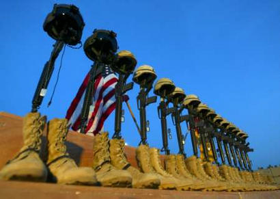A row of U.S. Army helmets are perched on M-16 rifles during a memorial at Al-Asad Air Base on Thursday, 6 November 2003, for the 15 victims of a Chinook helicopter which was shot down by insurgents on the weekend. Against a backdrop of 15 helmets resting on M-16 rifles, American soldiers on Thursday honored their comrades, victims of the single deadliest incident for U.S. forces since they invaded Iraq.