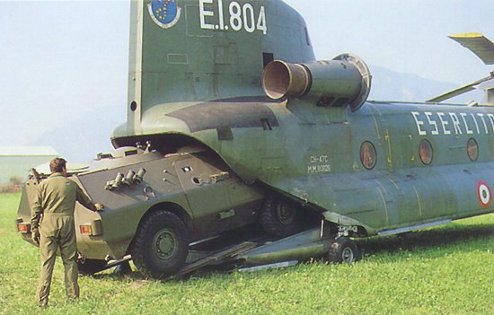 Italian aircrews load a vehicle aboard a Chinook helicopter somewhere in Europe.