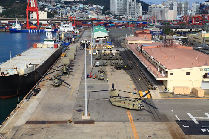 3 November 2013: Having arrived by ship only a few days earlier, maintenance personnel from Boeing assemble the airframes while flight crews inspect them for airworthiness on the dock at Pier 8, Buson, Republic of Korea (ROK). The photograph was taken from the first CH-47F Chinook helicopter to fly in the ROK, tail number 12-08103.