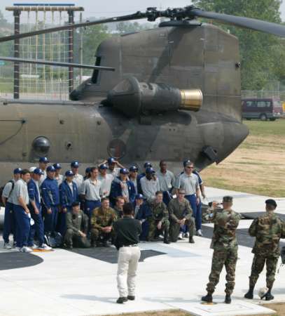 U.S. soccer players pose with a U.S. Army Chinook helicopter.