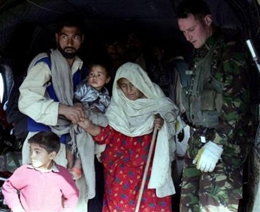 27 October 2005: Kashmiri earthquake survivors helped by a British Royal Air Force official arrive at a military airbase in Rawalpindi after being evacuated by a Chinook helicopter from the quake-hit area of Noseri, situated near Line of Control between Pakistan and Indian Kashmir. The world's failure to come up with quick cash to help save hundreds of thousands of Pakistani quake survivors before winter sets in left relief officials on the ground baffled and upset on Thursday.