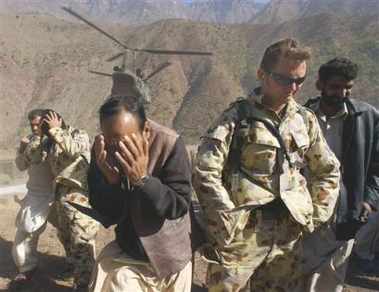 15 November 2005: In this handout photo provided by the Australian Department of Defense, Australian and Pakistani soldiers take cover from flying dust and grit in the downwash of an American Chinook helicopter taking off in Dahanni, Pakistan, on Tuesday. An Australian Defense Force medical team began to deploy into Pakistan mid November 2005 to provide vital health care assistance as part of the Australian Government's relief assistance to Pakistan following the earthquakes on 8 October 2005.