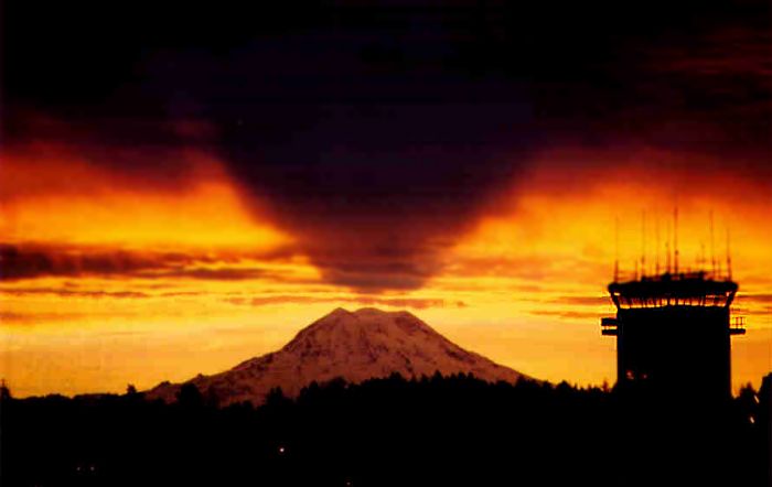 Sunrise at Gray Army Airfield, Fort Lewis, Washington, showing the control tower and Mount Rainier in the distance. Note the shadow cast by the mountain as the sun begins to rise. (22 October 2002)