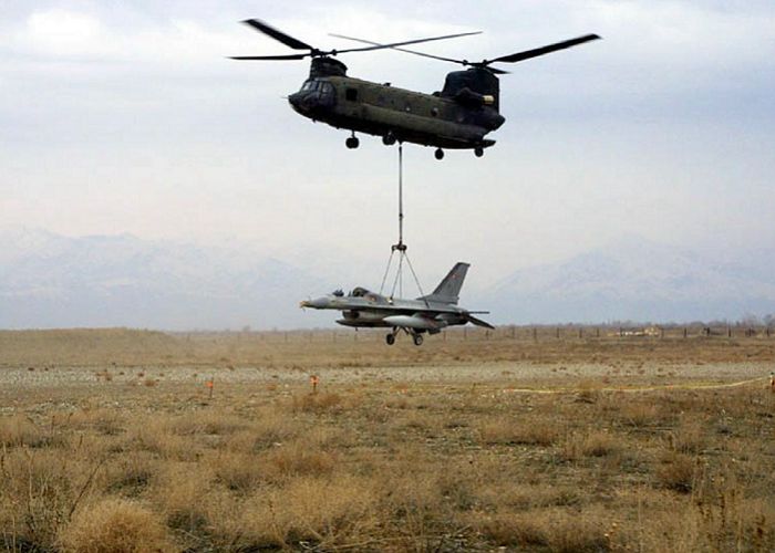 A CH-47D slings a stricken Danish F-16 out of a mine field.